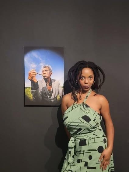 Image of writer, Shauntionne, posing with, "O Ancião," at A Mostra Foto Preta in Recife, Brazil. 